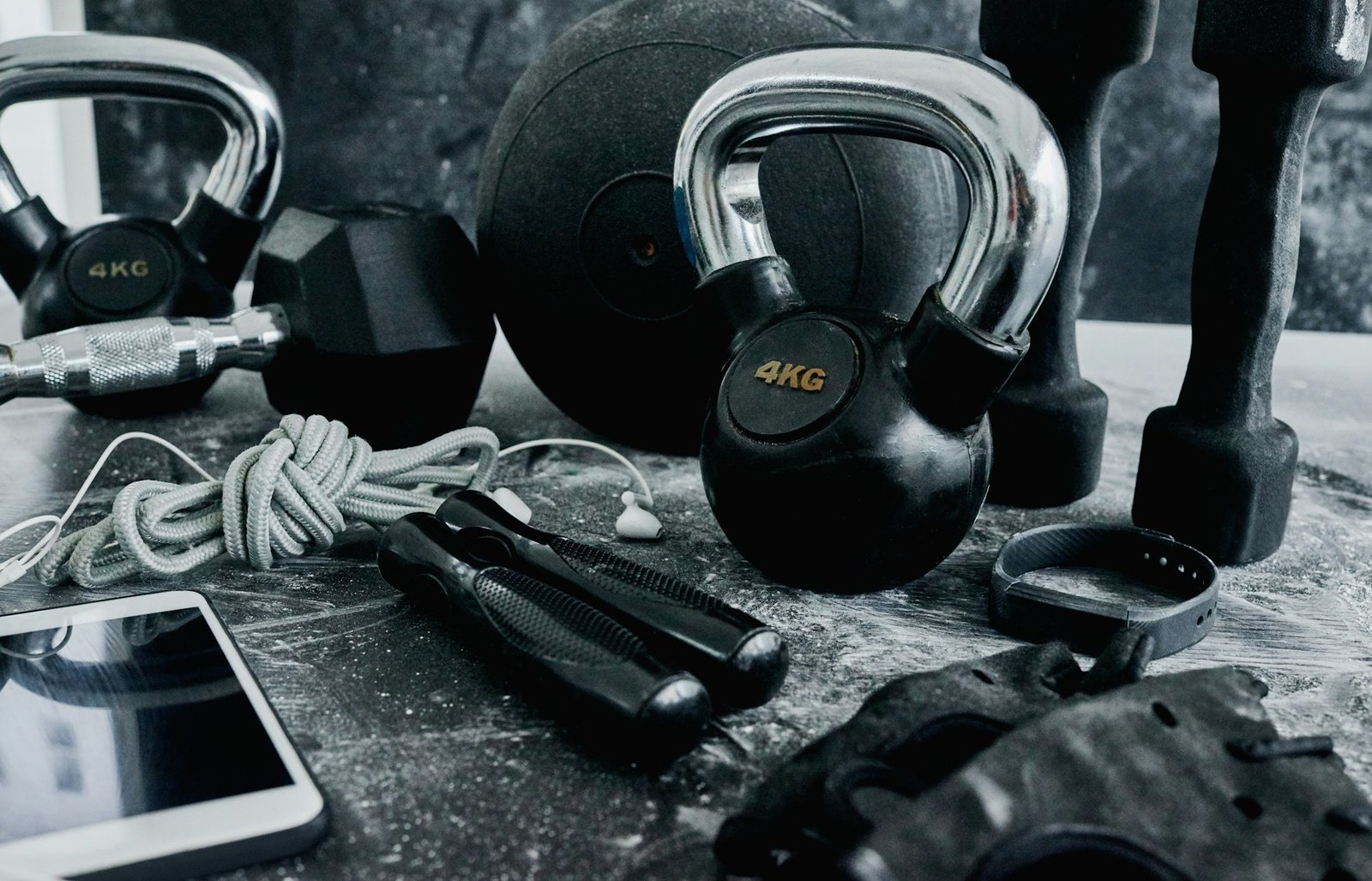 High angle shot of fitness workout essentials placed on top of a dark background inside of a studio